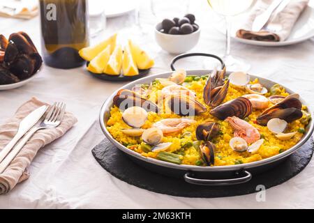 Spagnolo paella di frutti di mare con gamberi e vongole, cozze sul riso allo zafferano e verdure servita nel tradizionale padella sul ristorante tavolo. Foto Stock