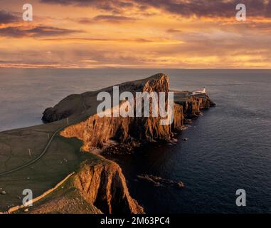 Isola di Skye nelle Highlands scozzesi, faro di Neist Point, affioramento nell'Oceano Atlantico. Vista aerea al tramonto guardando il faro Foto Stock