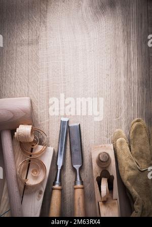 Mattoni di legno martello arricciato su palette planer scalpello più forte guanti di pelle su legno fondo costruzione concetto. Foto Stock