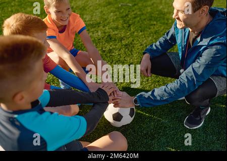 Allenatore di calcio motivante squadra di calcio junior prima della partita Foto Stock