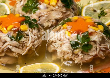 Aspico di carne decorato con melograno, piselli verdi, carota e prezzemolo. Piatto da ristorante per una festa celebrativa selettiva focus. Foto Stock