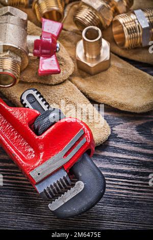 Set di guanti di protezione per utensili idraulici in ottone su tavola di legno. Foto Stock