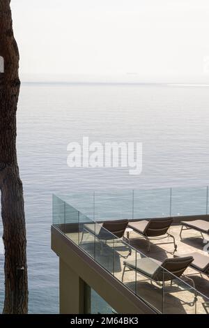 Terrazza con lettini di fronte al Mar Mediterraneo a Camogli, villaggio di pescatori e località di villeggiatura vicino alla penisola di Portofino, nella Riviera di le Foto Stock