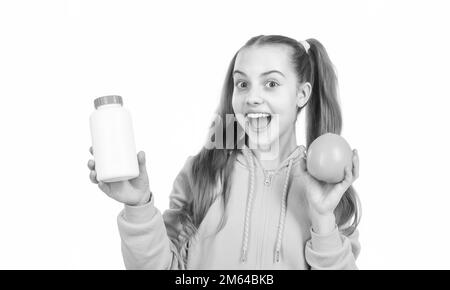 ragazza felice teen scegliere tra frutta d'arancia e pillola di vitamina isolato su bianco, supplemento minerale. Foto Stock