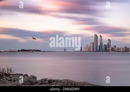 Una lunga esposizione dello skyline di Abu Dhabi al tramonto negli Emirati Arabi Uniti. Foto Stock