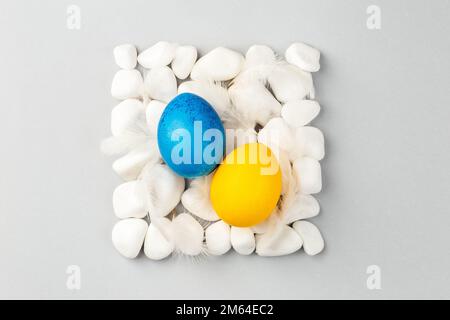 Uova di Pasqua ucraine dipinte di blu e giallo. Colori della bandiera nazionale. Sostenere l'Ucraina Foto Stock