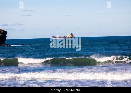 Portreath, Cornovaglia, 2nd gennaio 2023, la gente era fuori per una passeggiata mattutina sulla spiaggia durante l'alta marea a Portreath, Cornovaglia. Il cielo era blu con sole glorioso e 8C, la previsione dopo oggi è per il tempo bagnato per i prossimi giorni. La petroliera Maersk Bering è stata ancorata appena al largo della riva, il che è molto insolito.Credit: Keith Larby/Alamy Live News Foto Stock