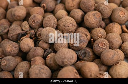 Mucchio di frutti di allspezia secchi spezie macrosone. Foto Stock