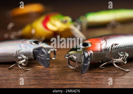 Esche di pesca colorate, wobbler, spinner, su banco di legno diverse esche da pesca Foto Stock