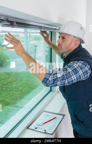 Operaio edile costruzione nuova casa e finestra di montaggio Foto Stock