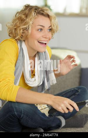 donna felice guardando qualcosa in tv Foto Stock
