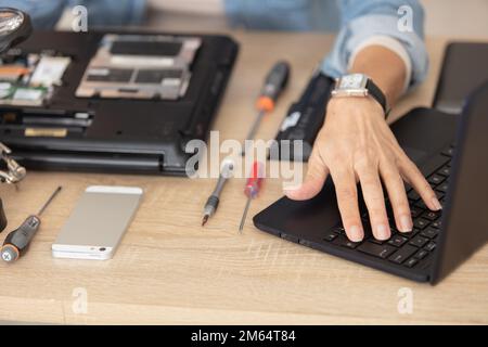 vista dall'alto di hands works su gadget elettronico rotto Foto Stock