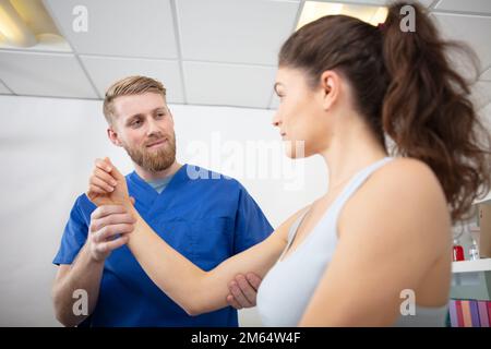 fisioterapista maschile che dona massaggio a una paziente femminile Foto Stock
