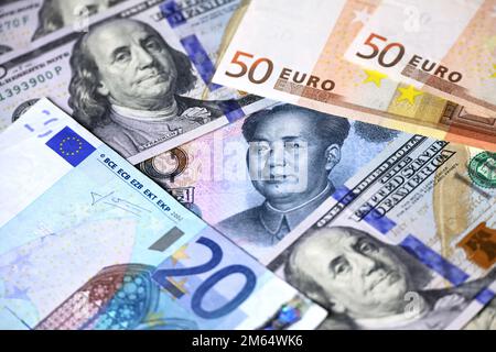 Yuan cinese circondato da dollari USA e banconote in euro. Concetto di guerra commerciale tra Cina e Stati Uniti, tasso di cambio, economia globale Foto Stock