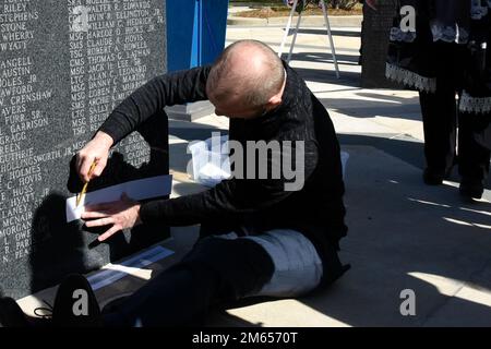 Amici e familiari trascrivono i nomi degli Airmen caduti su carta durante la cerimonia annuale di dedicazione del Memorial Wall tenutasi presso la base della Guardia Nazionale aerea del North Carolina, Charlotte Douglas International Airport, il 3 aprile 2022. Trentatré Airmen che servirono nella Guardia Nazionale dell'aria del North Carolina e passarono nel 2021 furono commemorati durante la cerimonia. Foto Stock