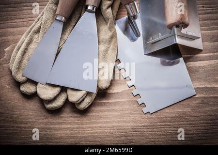 angolare due raschiatori per vernice guanti da lavoro coltello stucco. Foto Stock