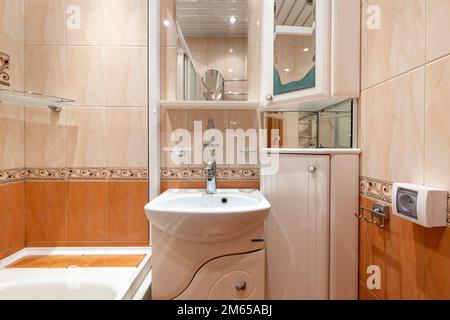 Foto di un bagno in colori pastello con le luci accese Foto Stock