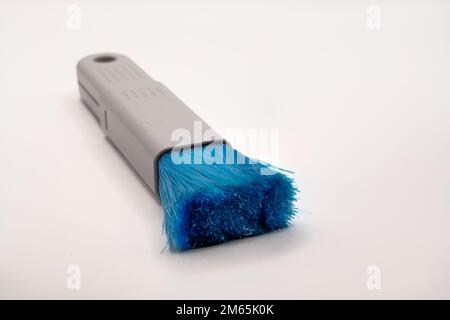 Primo piano di un PC estensibile in plastica e spazzola con setole in nylon blu Foto Stock