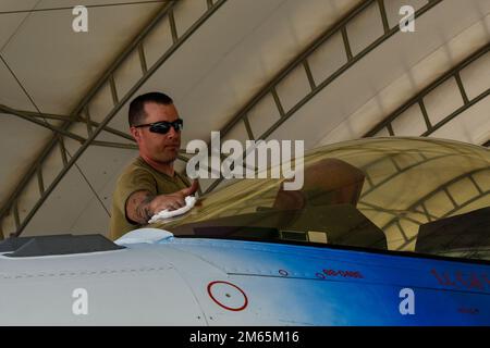 STATI UNITI Air National Guard Tech. Jonathan Lounsbery, 114th° capo equipaggio di manutenzione velivoli Squadron, pulisce la copertura di un F-16 durante il corso Weapons and Tactics Instructor (WTI) 2-22 alla Marine Corps Air Station Yuma, Ariz., 4 aprile 2022. WTI è un evento di formazione di sette settimane ospitato da Marine Aviation Weapons and Tactics Squadron One (MAWTS-1), che fornisce formazione tattica avanzata standardizzata e certificazione delle qualifiche di istruttore di unità per supportare la formazione e la preparazione dell'aviazione marina, e assiste nello sviluppo e nell'impiego di armi e tattiche aeronautiche. Foto Stock