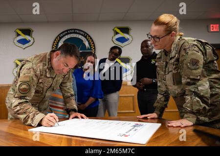 STATI UNITI Greg Moseley, comandante di 325th Fighter Wing, firma un proclama accanto al Capo Maestro Sgt. Kati Grabham, capo del comando di 325th Fighter Wing, e altri membri del Team Tyndall presso la base dell'aeronautica militare di Tyndall, Florida, 5 aprile 2022. Il bando ha dedicato il mese di aprile alla protezione e al sostegno degli Airmen e delle loro famiglie, riconoscendo una serie di programmi. Foto Stock