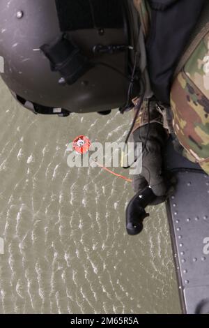 SGT. 1st Classe Kyle Moyer, un capo equipaggio di elicotteri UH-60m Black Hawk e un istruttore presso l'Eastern Army National Guard Aviation Training Site (EAATS), racconta al pilota dove guidare il secchio d'acqua durante l'addestramento il 5 aprile a Fort Indiantown Gap. Questa formazione congiunta tra EAATS e gli equipaggi antincendio di Conservation Wildland migliora la loro capacità di utilizzare i secchi d'acqua come risorsa per incendi boschivi o ustioni prescritte. Foto Stock