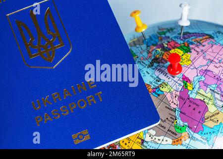 Ucraina, passaporto. I passaporti ucraini in mano sono sulla mappa del mondo. Concetto di viaggio Foto Stock