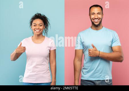 Sposi afro-americani eccitati che mostrano i loro pollici in su e sorridendo sullo sfondo rosa e blu dello studio Foto Stock