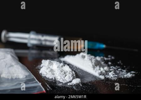 Concetto di tossicodipendenza. Immagini della Giornata internazionale contro l'abuso di droghe e il traffico illecito di droghe. Farmaci su sfondo nero Foto Stock
