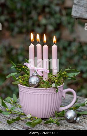 decorazione di natale con candele e rami di mistletoe in tazza Foto Stock