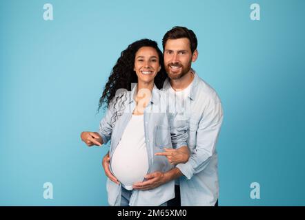 I futuri genitori felici godono l'amore e il rapporto. Felice giovane uomo europeo abbraccia donna incinta in casual Foto Stock