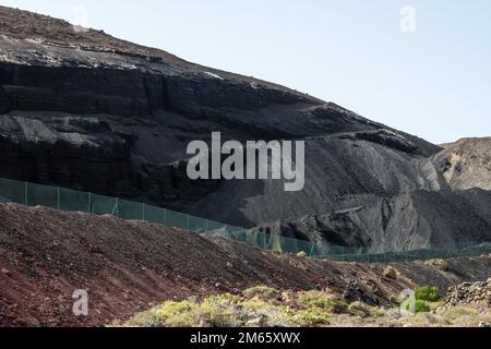 Il contrasto tra la laguna color smeraldo e i grani neri della spiaggia è così sorprendente. La spiaggia nera di Lanzarote, Isole Canarie Foto Stock