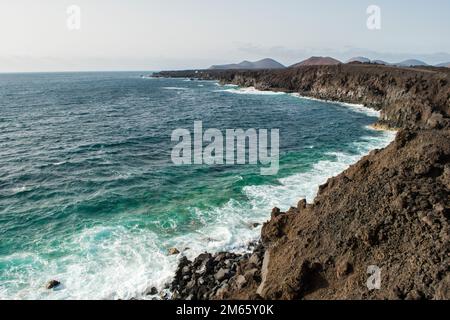 Il contrasto tra la laguna color smeraldo e i grani neri della spiaggia è così sorprendente. La spiaggia nera di Lanzarote, Isole Canarie Foto Stock