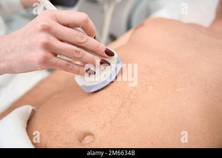 Il medico effettua un esame ecografico completo di un uomo di mezza età Foto Stock