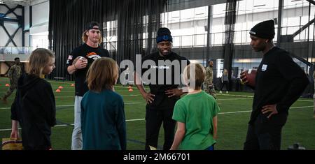 Andrew Beck, un Denver Broncos Tight End, Demetric Felton, Jr. A Cleveland Browns Running Back e Kenny Moore II, un Indianapolis Colts Cornerback, partecipa a una clinica della National Football League presso la base aeronautica di Eielson, Alaska, 6 aprile 2022. L'evento organizzato dall'USO ha incluso un po' di tempo per le famiglie Airmen ed Eielson per fare pratica, scattare foto e ottenere autografi dai giocatori della NFL. Foto Stock