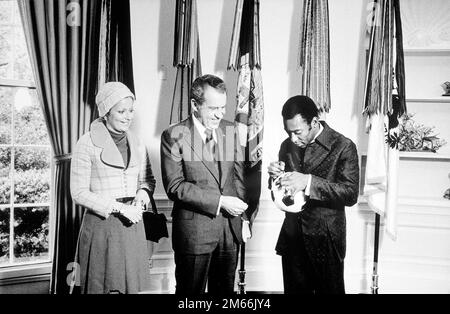 Il presidente Nixon incontra Edson 'Pele' Arantes do Nacimento, ex giocatore di calcio brasiliano e direttore del programma internazionale di calcio sponsorizzato da PepsiCo. 'Pele' autografa una palla di calcio per il presidente Nixon, 1973 Foto Stock