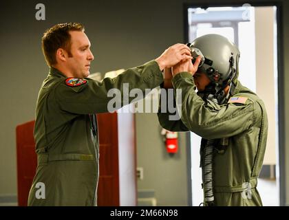 Il Major Kevin 'Sajaca' Donovan, pilota di 131st Fighter Squadron, assiste un cadetto del corpo di addestramento ufficiale della Yale Air Force Reserve durante un tour della 104th Fighting Wing il 8 aprile 2022, alla base della Guardia Nazionale dell'aria di Barnes, Massachusetts. Il tour ha rafforzato il rapporto tra il programma AFROTC e i membri della base, dando anche ai cadetti l'opportunità di conoscere la Guardia Nazionale aerea. Foto Stock