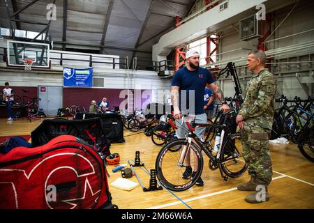 Stati Uniti ritirati Ross Alewine parla con il comando Sgt. Major dell'Esercito Michael Grinston durante l'Invictus Games Team U.S. del 2022 Campo di addestramento, Fort Belvoir, Virginia, 8 aprile 2022. Il Team U.S fa parte di oltre 500 partecipanti provenienti da 20 paesi che parteciperanno agli Invictus Games The Hague 2020 con dieci sport adattivi, tra cui tiro con l'arco, campo, canottaggio al coperto, powerlifting, nuoto, pista, pallavolo seduta, basket su sedia a rotelle, sedia a rotelle rubino, e una sfida alla guida. Foto Stock