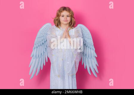 Angelo preghiera. Bambino piccolo cupido. Angelo bambino con ali angeli, isolato su sfondo rosa studio. Buono omaggio di San Valentino. Foto Stock