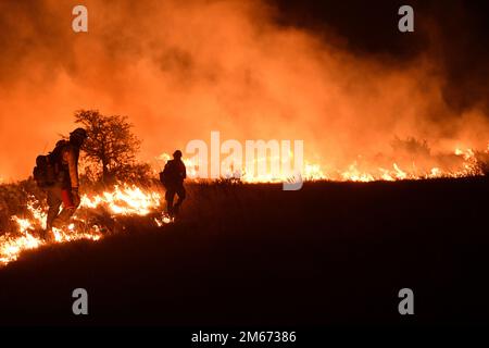 Texas state Forrest Service, Fredricksburg Task Force colpire i vigili del fuoco della squadra, accendere un controllato 'burn-out' per gestire l'area di un grande incendio 9 aprile 2022 presso Joint base San Antonio - campo di demolizione Bullis. JBSA-Camp Bullis comprende oltre 27.000 ettari di campi, aree di allenamento e terreni selvaggi sul lato nord di San Antonio ed è un punto di formazione fondamentale per i membri del servizio della base comune di San Antonio. Foto Stock