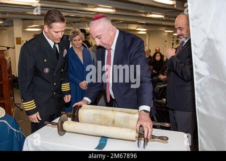 220410-N-NA545-1300 NEWPORT NEWS, VIRGINIA (10 aprile 2022) – il capitano Brent C. Gaut, lasciò, da Stockton, California, l'ufficiale comandante della portaerei di classe Nimitz USS George Washington, osserva come Rabbi Irving A. Elson, direttore del consiglio dei Cappellani ebraici, Svela la Torah prestata alla nave durante una cerimonia di redimissione della Torah e di inaugurazione dell'Arca nel foc'sle della nave. George Washington è in fase di revisione del complesso di rifornimento (RCOH) presso il cantiere navale di Newport News. RCOH è un progetto pluriennale eseguito una sola volta durante i 50 anni di vita di un vettore che include Foto Stock