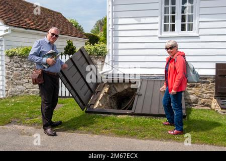 Winchelsea East Sussex UK visitatori che guardano la porta aperta di una delle 33 cantine storiche accessibili nel villaggio occasionalmente aperto al pubblico Foto Stock