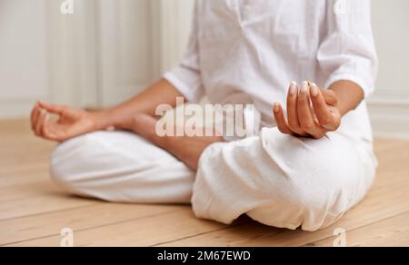 Zona priva di stress. una donna seduta nella posizione del loto durante una sessione di yoga. Foto Stock