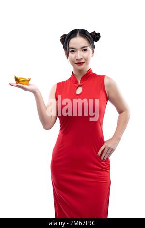 Donna cinese asiatica in un vestito di gongsam che tiene un lingotto d'oro cinese isolato su sfondo bianco Foto Stock