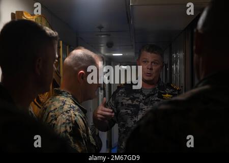 Royal Australian Navy Lt. CMdR. Adrian Hicks, il comandante della nave Australiana di sua Maestà (HMAS) Armidale, descrive la vita quotidiana delle navi negli Stati Uniti Christopher T. Steele, l'ufficiale comandante della Marina Rotational Force-Darwin 22, durante un tour in nave a Darwin, NT, Australia, 13 aprile 2022. Il tour si è svolto per sviluppare una migliore comprensione dell'HMAS Armidale e per esplorare come i Marines possano effettivamente integrarsi con le forze australiane. Foto Stock