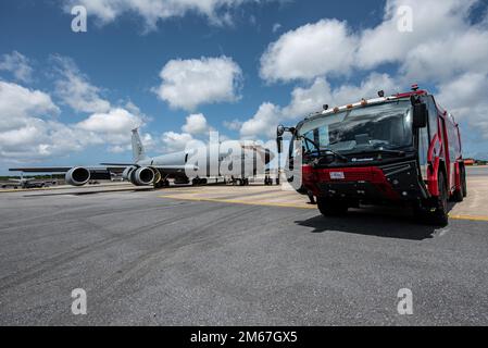 Un veicolo antincendio Squadron Rosenbauer PANTHER, ingegnere civile del 18th, è parcheggiato accanto a uno Squadron KC-135 Stratotanker per rifornimento aereo del 909th per l'addestramento alla base aerea di Kadena, Giappone, il 12 aprile 2022. L'addestramento ha valutato le capacità di salvataggio e recupero di 18th vigili del fuoco CES durante un incendio del motore KC-135 o della cabina di pilotaggio. Foto Stock