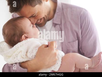 HES un papà doting. un giovane padre che tiene la sua adorabile bambina e mostra il suo affetto. Foto Stock