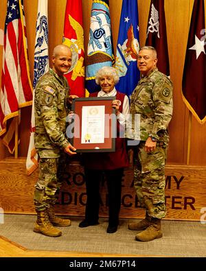 Brooke Army Medical Center comandante Generale Brig. Il generale Clinton Murray (a sinistra) e il comando Sgt. Major Thurman Reynolds (a destra) presentano Shirley Adcock il premio "Rosa gialla del Texas" del governatore del Texas durante la cerimonia di riconoscimento volontario a BAMC, Fort Sam Houston, Texas, il 13 aprile 2022. Il 94-year-old sta ritirando dal servizio volontario dopo aver servito quasi 26 anni alla BAMC. Foto Stock