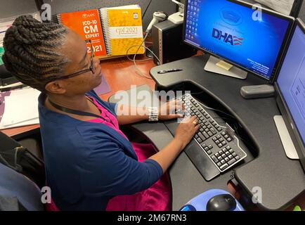 JACKSONVILLE, Florida (13 aprile 2022) - Chalonda Hobbs, un tecnico di cartelle cliniche presso l’ufficio di codifica del Naval Hospital Jacksonville, si prepara a rivedere la cartella clinica di un paziente. Hobbs, originario di Augusta, Georgia, afferma: “Supportiamo i fornitori nel garantire che le condizioni mediche e i trattamenti siano documentati in modo accurato”. La settimana del riconoscimento del servizio pubblico (1-7 maggio) onora le persone che servono la nostra nazione come dipendenti federali, statali, regionali e locali. Foto Stock