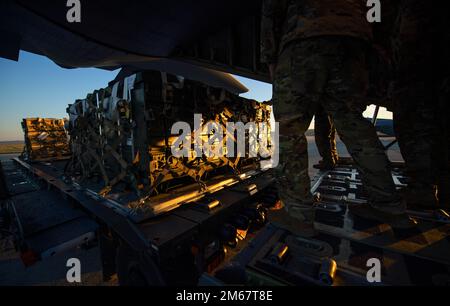 STATI UNITI I militari scaricano pallet di carico da un C-130 Hercules nell'Europa orientale, 13 aprile 2022. Insieme alle nazioni partner e agli alleati, 621st Contingency Response Wing Airmen ha consegnato il carico alle operazioni a supporto degli Stati Uniti Comando europeo. Foto Stock