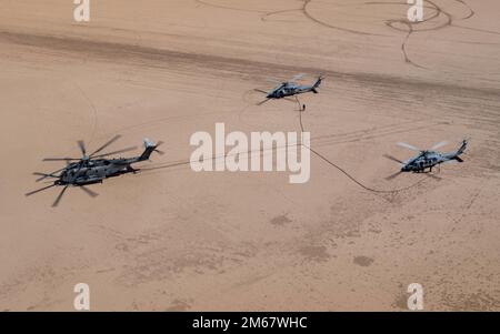 220414-N-GW654-1618 OCOTILLO WELLS, California (Apr. 14, 2022) – due MH-60s Seahawks assegnati ai “Blackjack” di Helicopter Sea Combat Squadron (HSC) 21 ricevono carburante da un CH-53E Super Stallion assegnato a “Flying Tigers” di Marine Medium Helicopter Squadron 361 (HMH-361) il 14 aprile. HSC-21 ha partecipato a una prova di concetto che mostra le capacità di squadra senza equipaggio (MUMT) utilizzando sia con equipaggio e senza equipaggio per realizzare una missione, che ha incluso il rifornimento di equipaggio di MH-60s assistito da due CH-53E Super Stallioni assegnati a HMH-361, e MUMT ricerca e operazioni di salvataggio Foto Stock